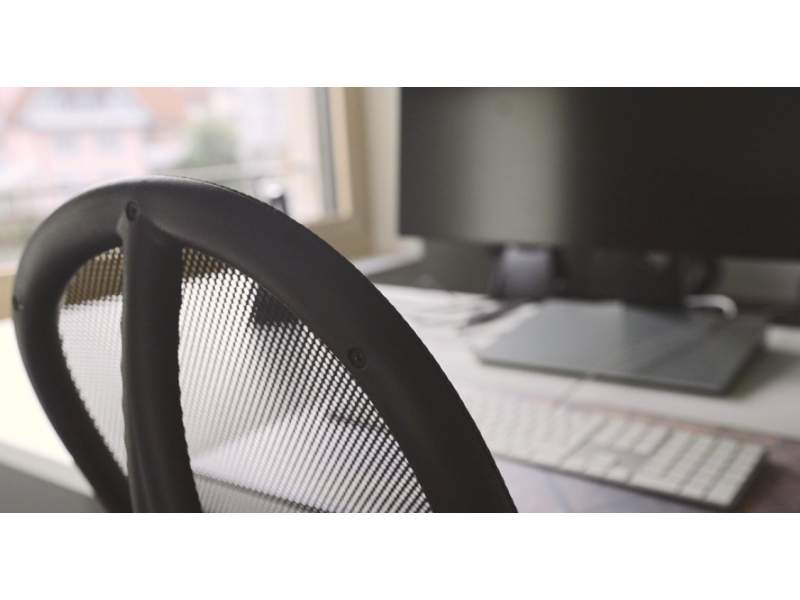 Ergonomischer Büroarbeitsplatz mit Mesh-Bürostuhl und moderner Bildschirmarbeitsstation