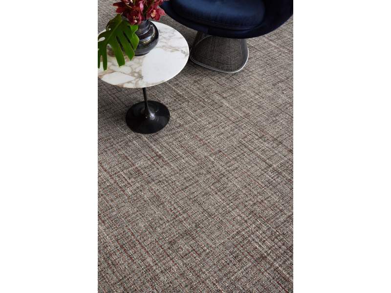 Interface Thread Lightly Teppichfliesen in einer Loungezone mit Beistelltisch und Sesseln
