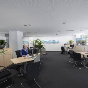 Open-Space-Büro der Creditplus Bank AG in Berlin mit integrierter ERCO Beleuchtung und klarer Arbeitsplatzstruktur