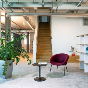Lista Office LO Büroplanung Pierre Fabre Pharma AG Loungebereich mit Sessel, Beistelltisch und Treppenaufgang in offener Bürostruktur