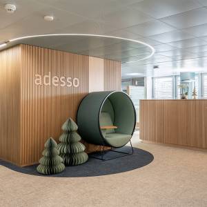 Lista Office LO Büroplanung adesso Schweiz AG Empfangsbereich mit Holzverkleidung, Sitznische und Markenbeschriftung im Eingangsbereich
