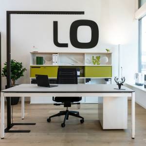 Lista Office LO Neuchâtel Showroom Arbeitsplatz mit Schreibtisch, Stauraum und Markenlogo im Hintergrund