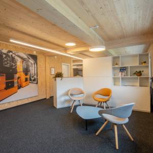 Schäfer Shop AG Begegnungszone der Schmid AG energy solutions mit Lounge-Sitzgruppe und Holzinnenausbau