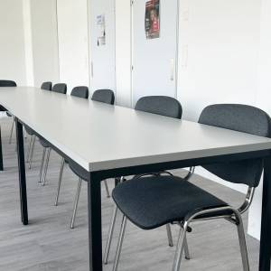 Moderner Schulungsraum der Alemania Deutschschule mit grosszügigen Tischen und stapelbaren Stühlen