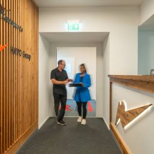 Moderner Empfangsbereich der HAVO Group AG mit Holzdetails und beleuchtetem Logo