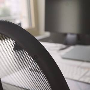Ergonomischer Büroarbeitsplatz mit Mesh-Bürostuhl und moderner Bildschirmarbeitsstation
