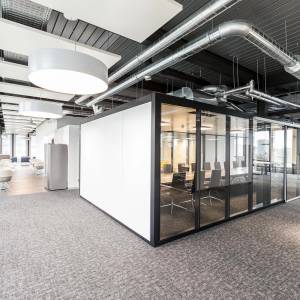 Goldbach Kirchner GK SPACES Raum-in-Raum-System mit verglastem Besprechungsraum in einer offenen Büroumgebung