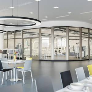 Goldbach Kirchner Brandschutztür mit Glasfüllung integriert in eine transparente Trennwand eines modernen Aufenthaltsbereichs