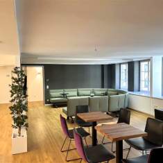 Offener Lounge-Bereich im Satellite Office Ludwigpalais mit großem, hellgrünem Sofa, Holztischen und modernen Stühlen