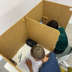 Schüler arbeiten mit dadoEASY Trennwänden in gelber Filzfarbe an ihren Schreibtischen