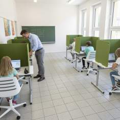 dadoEASY Lernarbeitsplätze im Klassenzimmer mit grünen Sichtschutzwänden für konzentriertes Arbeiten