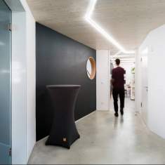 Flur im Gründersaal Tübingen mit Glaswänden, moderner LED-Deckenbeleuchtung und minimalistischer Innenarchitektur.