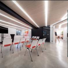 Seminarraum im Gründersaal Tübingen mit LED-Lichtlinien, Whiteboards und weißen Stühlen für Workshops und Meetings.