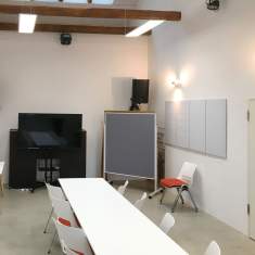 Meetingraum im Gründersaal Tübingen mit großem Display, stapelbaren Stühlen und moderner Workshop-Ausstattung