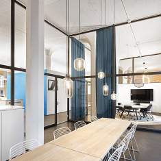 Meetingbereich mit langem Holztisch und Glasabtrennungen in der inspirierenden Arbeitswelt von Sennheiser Zürich