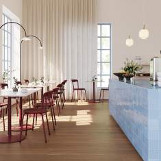 Materia Ina Stühle im Café- und Kantinenbereich mit Tischen und Barbereich im Innenraum
