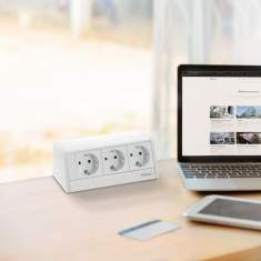EVOline R-Dock Steckdosenmodul auf dem Schreibtisch im Einsatz am Arbeitsplatz neben Laptop und Tablet