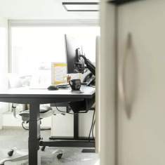 Schäfer Shop AG Arbeitsplatz der Gsell Fenster GmbH mit höhenverstellbarem Schreibtisch und Monitorarm