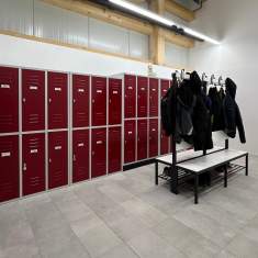 Umkleideraum mit roten Garderobenschränken und Sitzbank bei der Blumenbörse West Genossenschaft