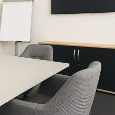 Besprechungsbereich mit Stauraummöbel und Bildschirm im neuen SORENOS Büro