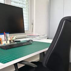 Detailaufnahme eines modernen Arbeitsplatzes mit Bürostuhl und Bildschirm bei SORENOS