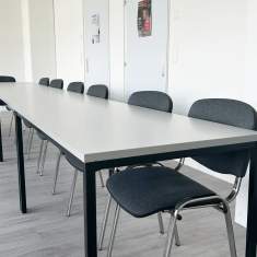 Moderner Schulungsraum der Alemania Deutschschule mit grosszügigen Tischen und stapelbaren Stühlen