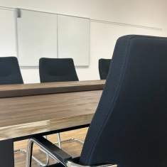 Moderner Besprechungsraum der Schule Egerkingen mit Konferenztisch und schwarzen Besucherstühlen