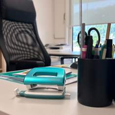 Detailaufnahme eines ergonomischen Büroarbeitsplatzes mit Bürostuhl und Schreibutensilien in der Schulverwaltung