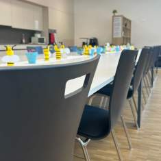 Heller Sitzungsraum der Schule Egerkingen mit langen Besprechungstischen und stapelbaren Stühlen