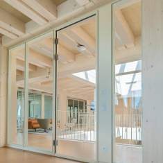 Goldbach Kirchner Ganzglas-Tür in einer transparenten Trennwandkonstruktion mit Holzarchitektur