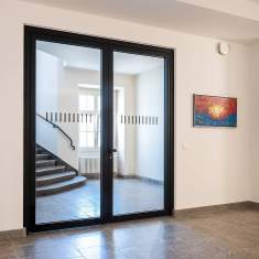 Goldbach Kirchner zweiflügelige Rohrrahmentür mit schwarzem Aluminiumrahmen und Glasfüllung in einem Eingangsbereich
