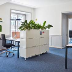 Embru eQ Vierbeintisch Arbeitstisch – mehrere Arbeitsplätze zwischen begrünten Stauraumelementen in einer offenen Büroumgebung